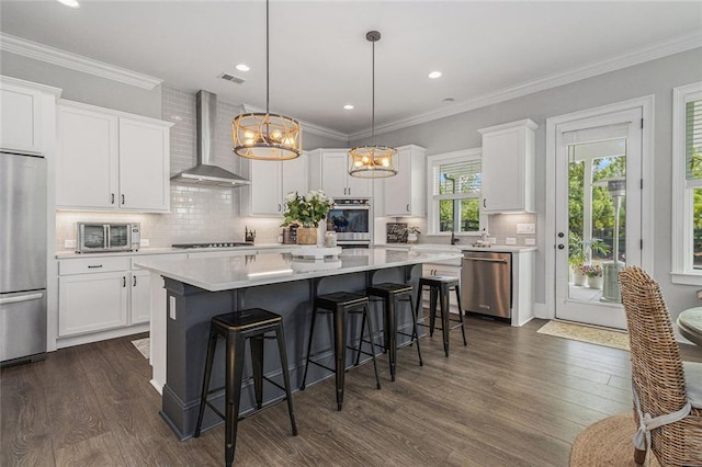 1865 Henley Way, Alpharetta, GA 30009 - kitchen featuring wall chimney range hood, appliances with stainless steel finishes, white cabinetry, a breakfast bar, and light countertops