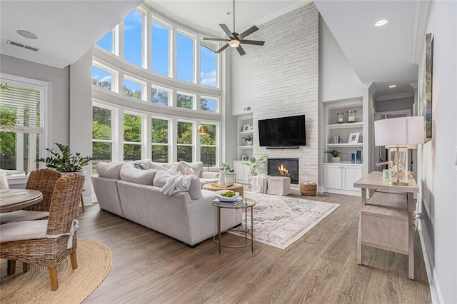 1865 Henley Way, Alpharetta, GA 30009 - living area with ceiling fan, a fireplace, wood finished floors, a high ceiling, and ornamental molding