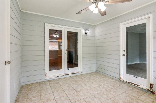 unfurnished sunroom with a ceiling fan and french doors