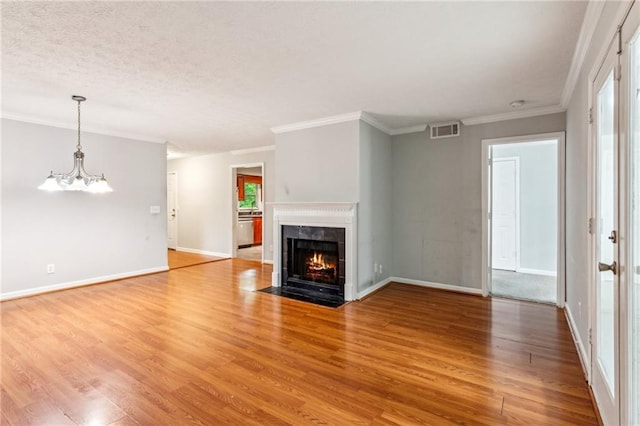 unfurnished living room featuring light wood-style floors, a high end fireplace, baseboards, crown molding, and a chandelier