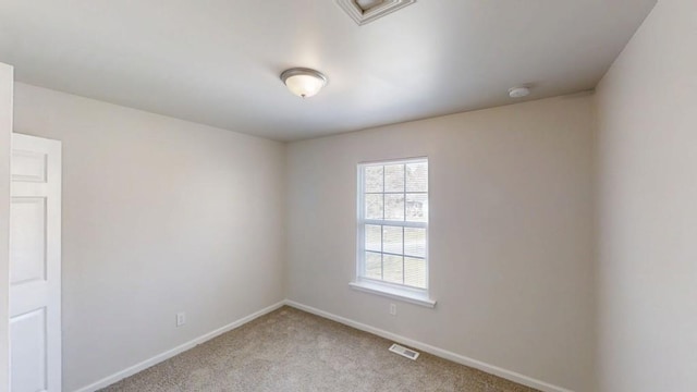 empty room with visible vents, light colored carpet, and baseboards