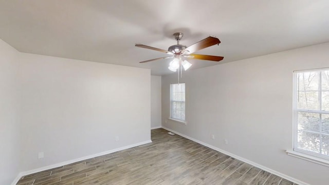 empty room with a ceiling fan, light wood-type flooring, and baseboards