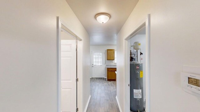 hallway with light wood-style floors and electric water heater