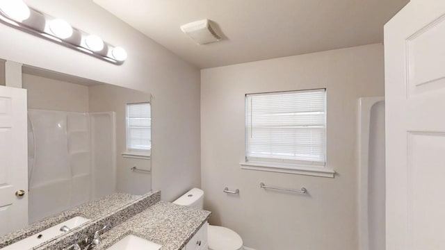 bathroom with a shower, toilet, and vanity