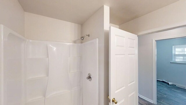 full bathroom featuring wood finished floors and a shower