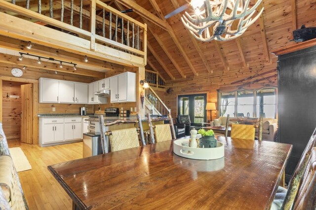 852 Black Bear Den Rd, Clayton, GA 30525 - kitchen with wood walls, washer and clothes dryer, rail lighting, a sink, and appliances with stainless steel finishes