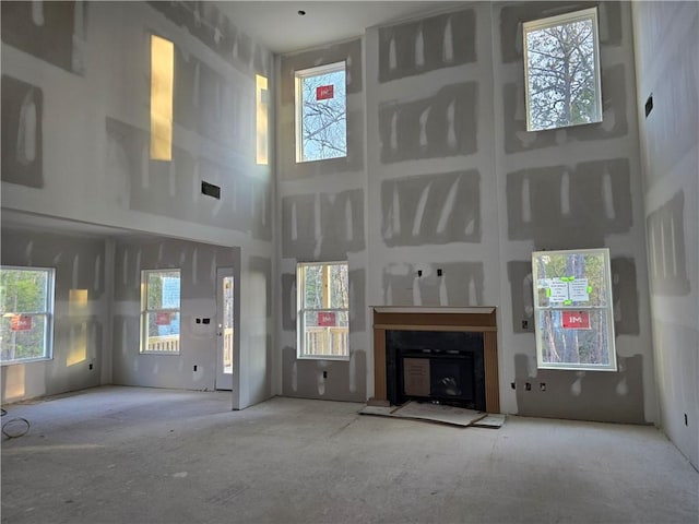 unfurnished living room with a healthy amount of sunlight and a towering ceiling