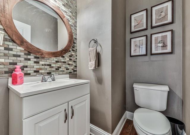 kitchen with crown molding, white cabinets, decorative backsplash, double oven, and wood finished floors