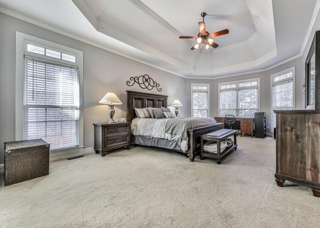 kitchen with a sink, ceiling fan, a peninsula, wood finished floors, and stainless steel appliances