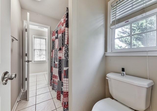 full bathroom featuring tile patterned floors, toilet, curtained shower, and baseboards