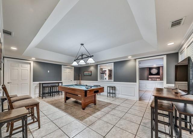 rec room with visible vents, light tile patterned floors, a tray ceiling, a wainscoted wall, and pool table