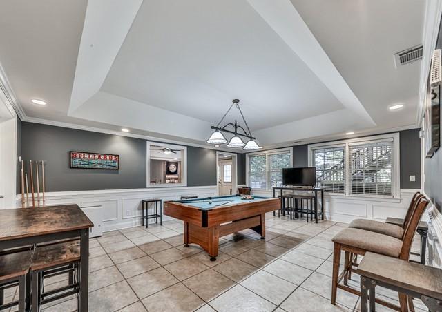 cinema featuring a tray ceiling, carpet flooring, ceiling fan, and ornamental molding