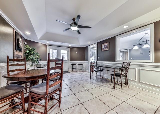 dining space featuring a decorative wall, a ceiling fan, a tray ceiling, recessed lighting, and tile patterned floors