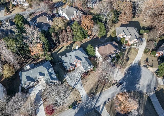 view of property's community with a water view, a view of trees, and a lawn