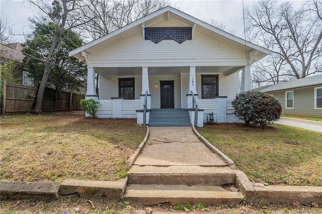 bungalow-style home with a porch, a front yard, and fence