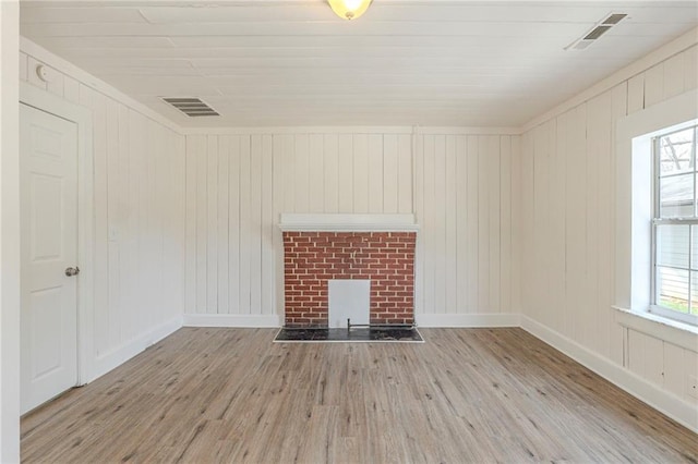 unfurnished living room featuring a fireplace, wood finished floors, visible vents, and baseboards