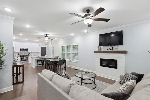 living room with ceiling fan, dark wood-type flooring, and crown molding