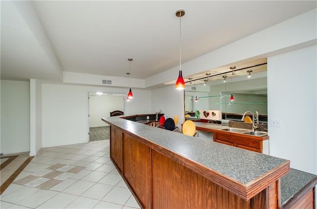 kitchen with sink, decorative light fixtures, light tile patterned flooring, and a kitchen island