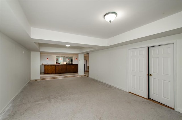 basement featuring bar and light carpet