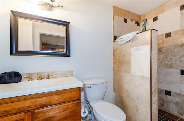 bathroom featuring vanity, tiled shower, and toilet