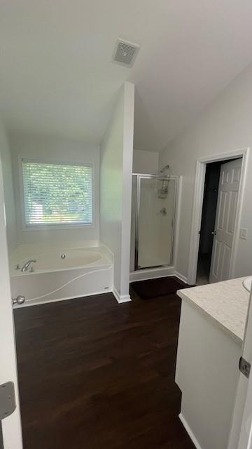 bathroom featuring hardwood / wood-style floors, lofted ceiling, separate shower and tub, and vanity