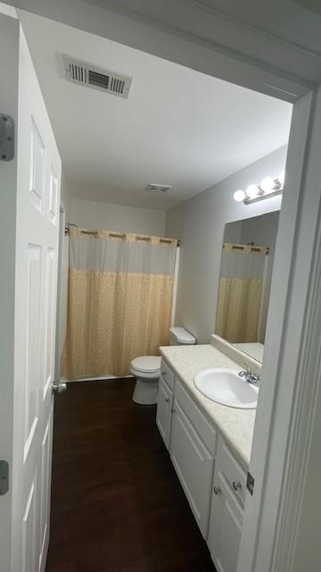 bathroom with hardwood / wood-style floors, vanity, and toilet