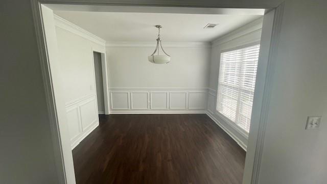 unfurnished dining area with dark hardwood / wood-style flooring and crown molding