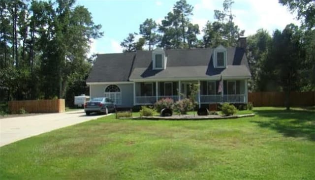 cape cod house featuring a porch and a front yard