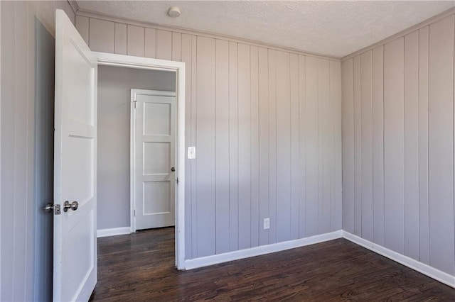unfurnished room featuring a textured ceiling and dark hardwood / wood-style floors