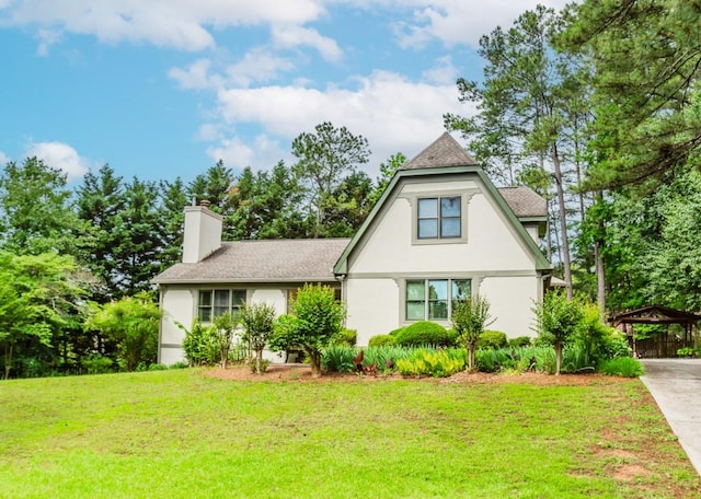 529 Arnold Rd, Lawrenceville, GA 30044 - view of front of house featuring a front yard, stucco siding, a chimney, and a detached carport