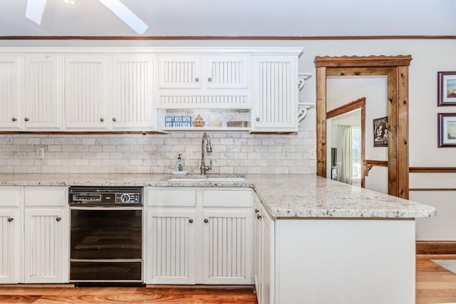 529 Arnold Rd, Lawrenceville, GA 30044 - kitchen with a sink, black dishwasher, a peninsula, light wood finished floors, and tasteful backsplash