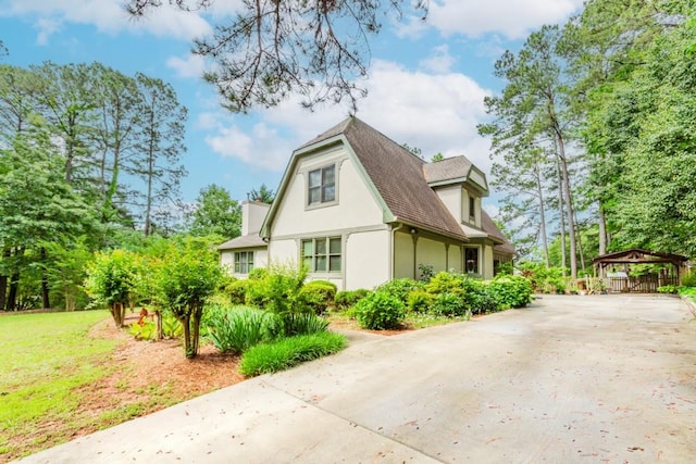 529 Arnold Rd, Lawrenceville, GA 30044 - view of home's exterior featuring stucco siding, a carport, a gazebo, driveway, and roof with shingles