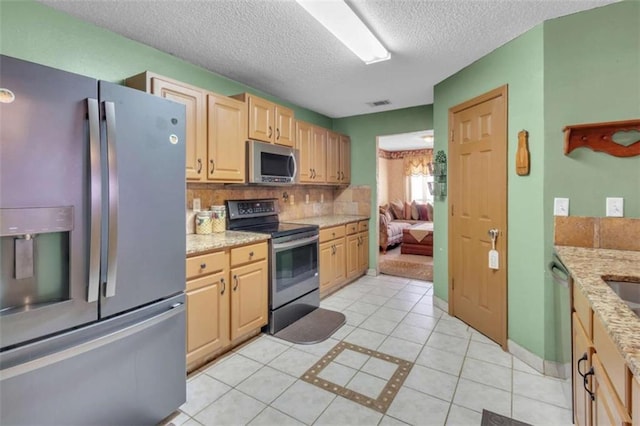 4969 Truitt Ln, Decatur, GA 30035 - kitchen featuring appliances with stainless steel finishes, light tile patterned floors, tasteful backsplash, a textured ceiling, and light brown cabinets