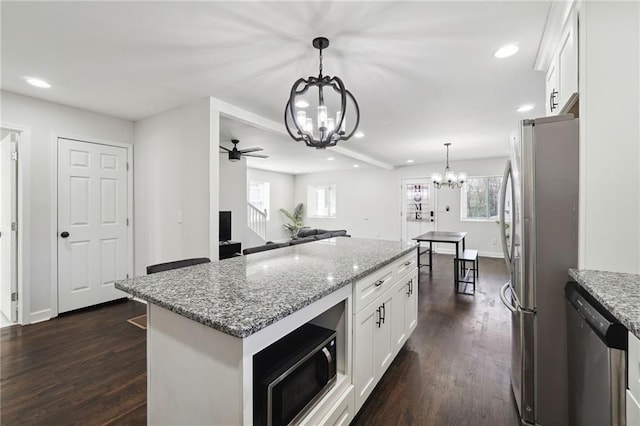 kitchen featuring white cabinets, plenty of natural light, decorative light fixtures, and appliances with stainless steel finishes