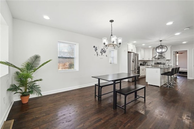 dining room with ceiling fan with notable chandelier and dark hardwood / wood-style floors