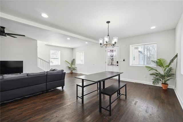 dining room with ceiling fan with notable chandelier and dark hardwood / wood-style floors