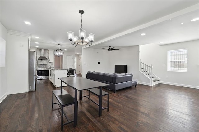 dining area with ceiling fan with notable chandelier and dark hardwood / wood-style flooring