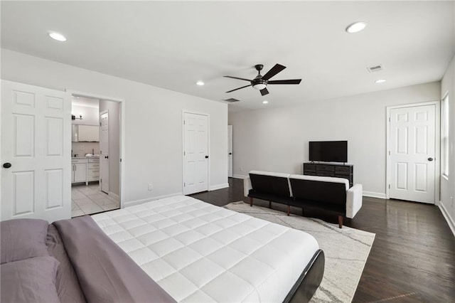 bedroom with ceiling fan, ensuite bathroom, and light wood-type flooring