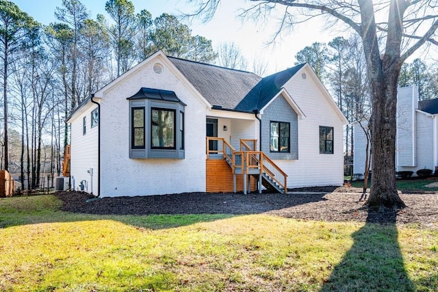 view of front facade with cooling unit and a front lawn