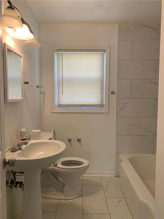 bathroom with baseboards, toilet, and marble finish floor