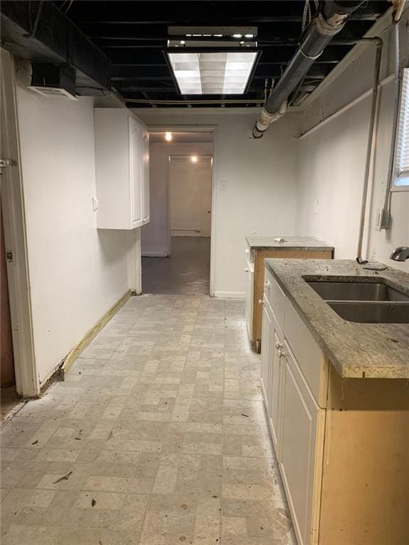 unfinished below grade area with light floors, baseboards, and a sink