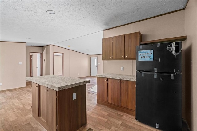 211 Fire Tower Rd NE, Calhoun, GA 30701 - kitchen featuring freestanding refrigerator, light wood-style floors, light countertops, crown molding, and a textured ceiling