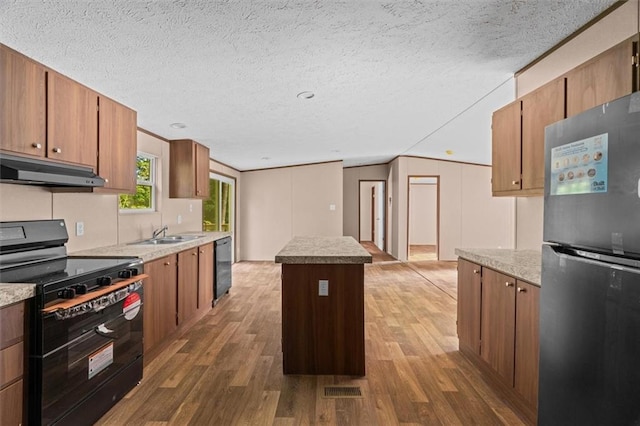 211 Fire Tower Rd NE, Calhoun, GA 30701 - kitchen featuring black appliances, under cabinet range hood, wood finished floors, a center island, and a sink