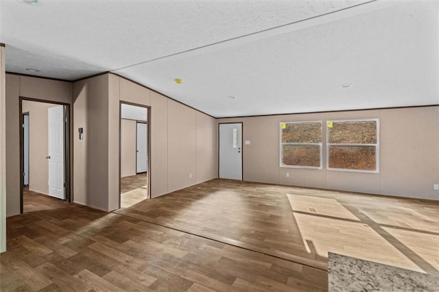 211 Fire Tower Rd NE, Calhoun, GA 30701 - empty room with wood finished floors, lofted ceiling, a textured ceiling, and ornamental molding