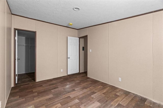 211 Fire Tower Rd NE, Calhoun, GA 30701 - unfurnished bedroom with wood finished floors, crown molding, a spacious closet, a textured ceiling, and a closet