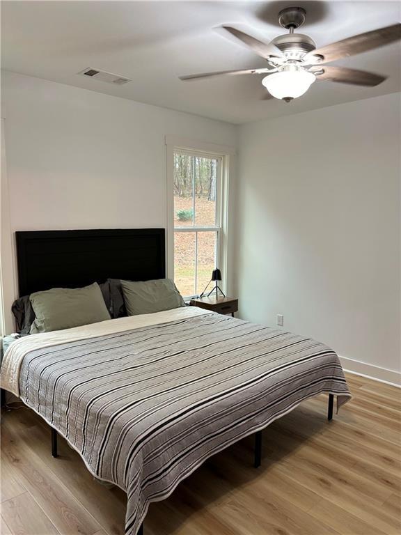 bedroom with ceiling fan and wood-type flooring