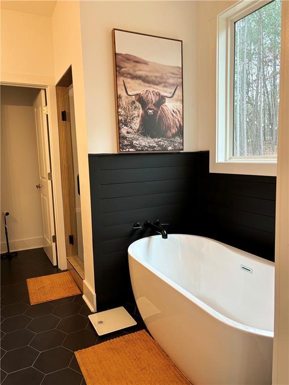 bathroom with tile patterned floors and a bathtub