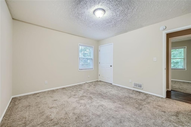 unfurnished room featuring a textured ceiling and hardwood / wood-style flooring