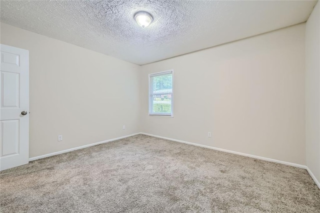 unfurnished room with a textured ceiling and carpet