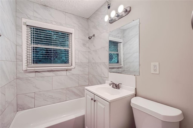 full bathroom featuring vanity, toilet, tiled shower / bath, and a textured ceiling